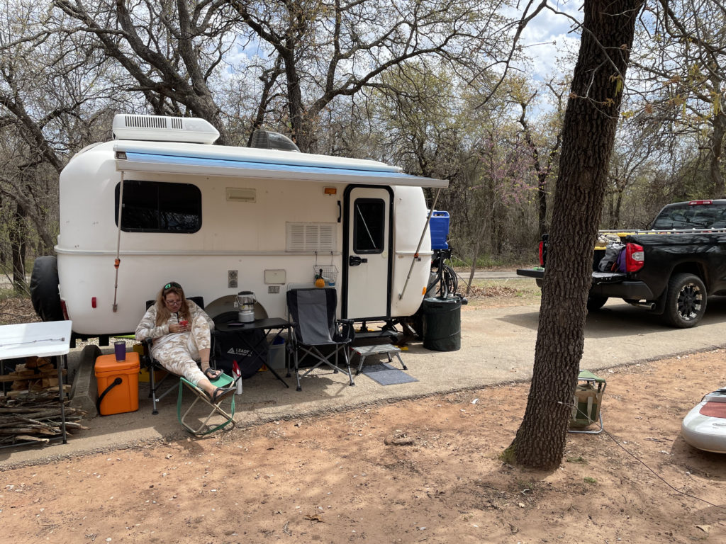 Corrie chilling at under the Casita awning at Lake Arcadia.