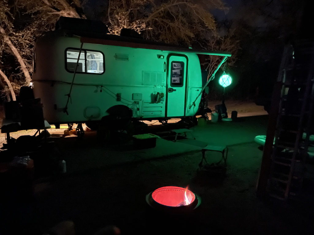 Casita at night with Solo Stove and green hue.